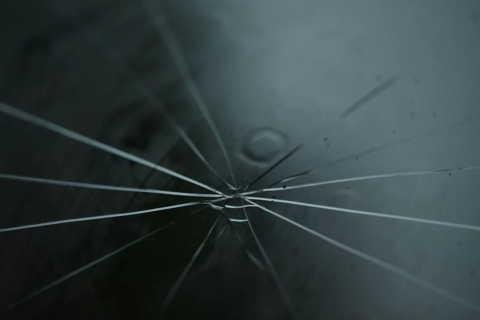 Cracks spreading out from one impact point in a pane of glass
