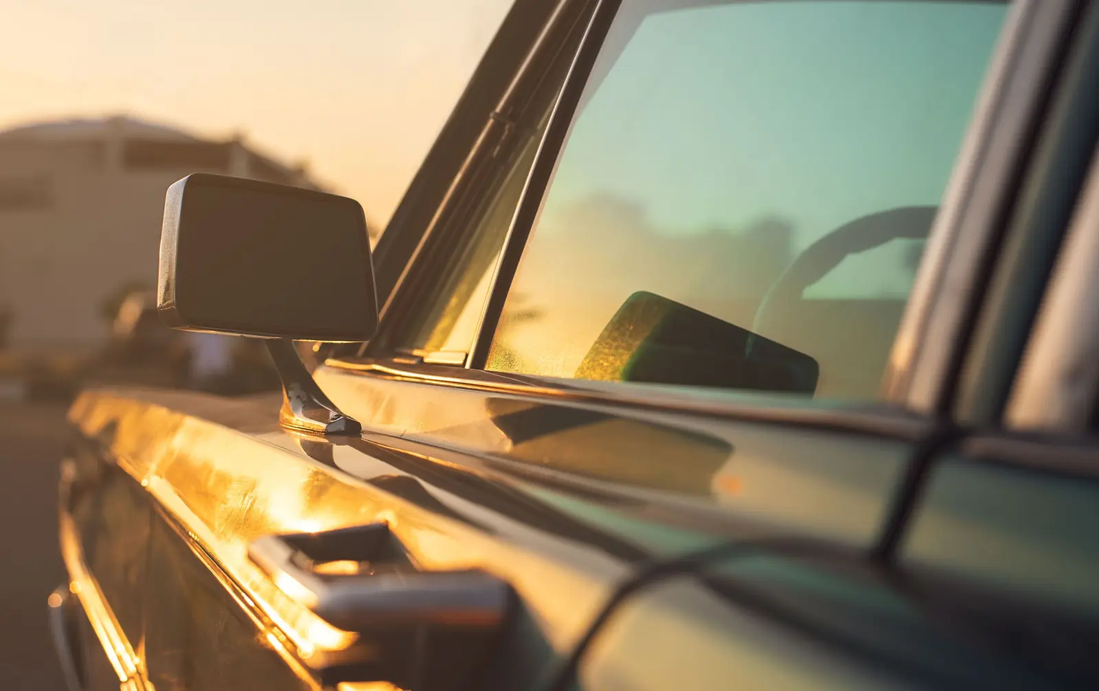Low evening sun on a car’s side window and door mirror